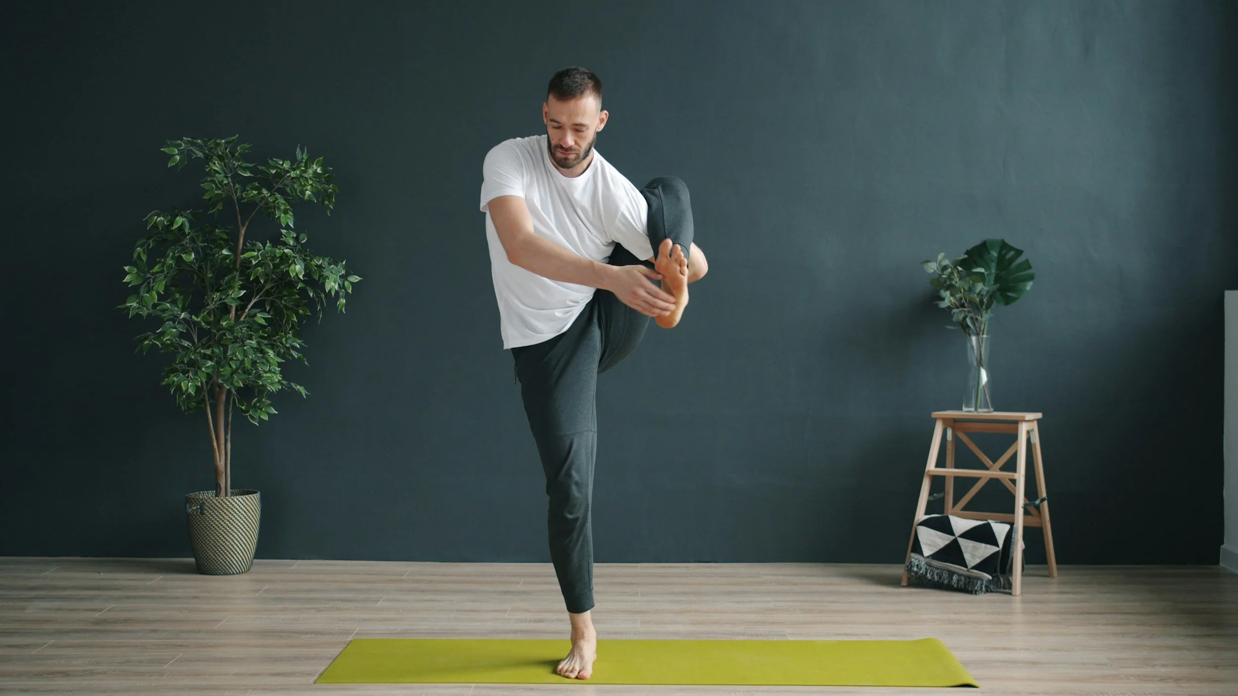 Hands handling fabric sample swatches on a wooden table with various textured and colored samples and small dishes around.