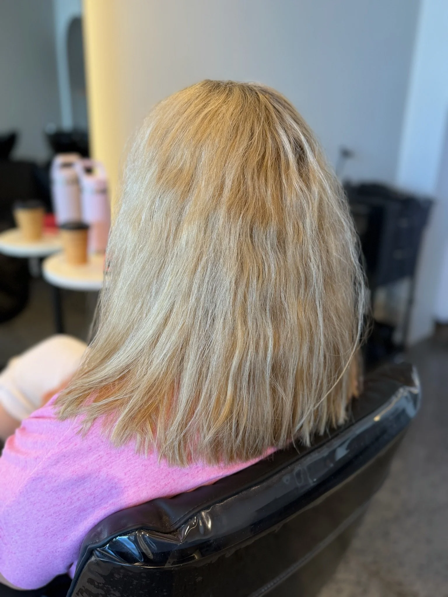 Before Nanoplasty hair straightening showing frizzy blonde hair prior to treatment at Straight & Sleek salon.