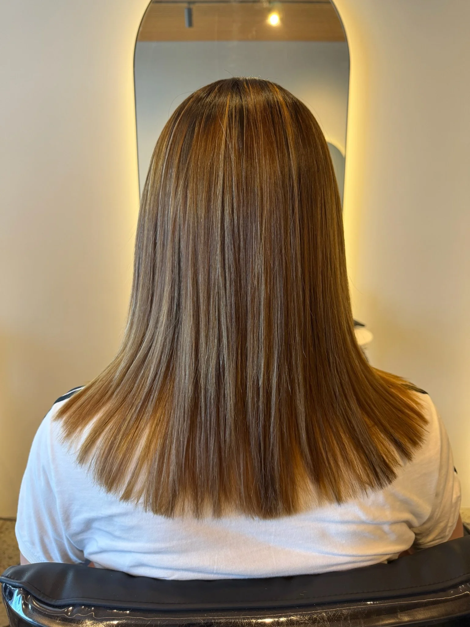 After Nanoplasty hair straightening showing smooth sleek brown hair result at Straight & Sleek salon.