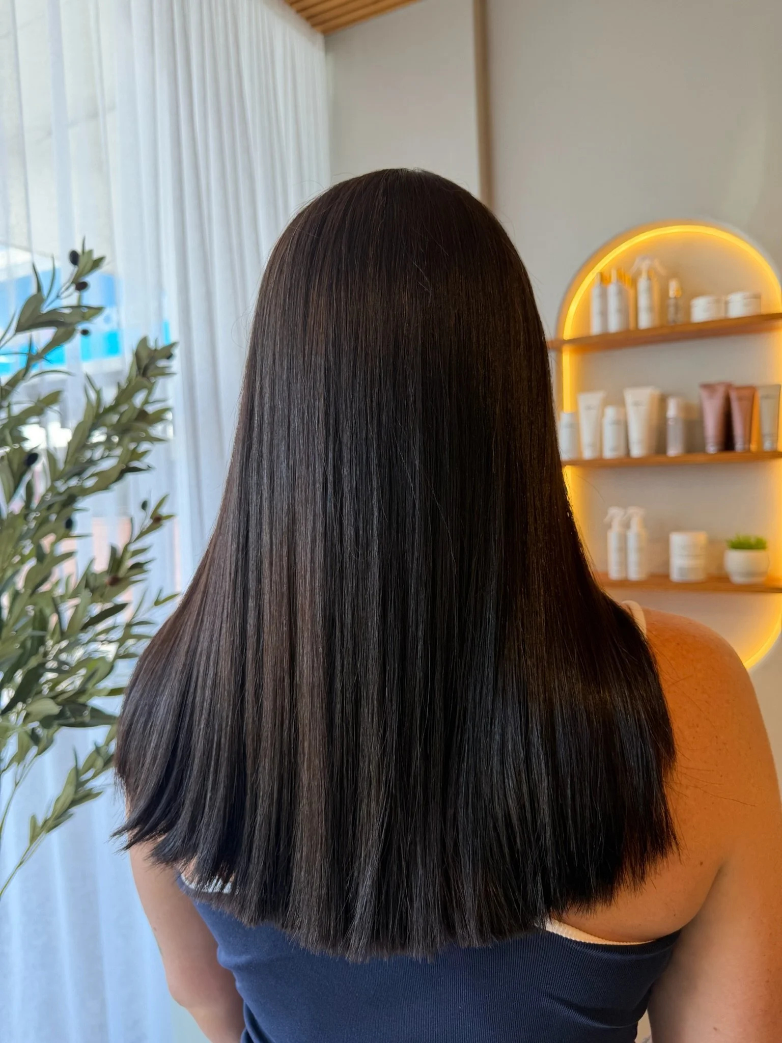 After Nanoplasty hair straightening showing smooth sleek dark hair result at Straight & Sleek salon.