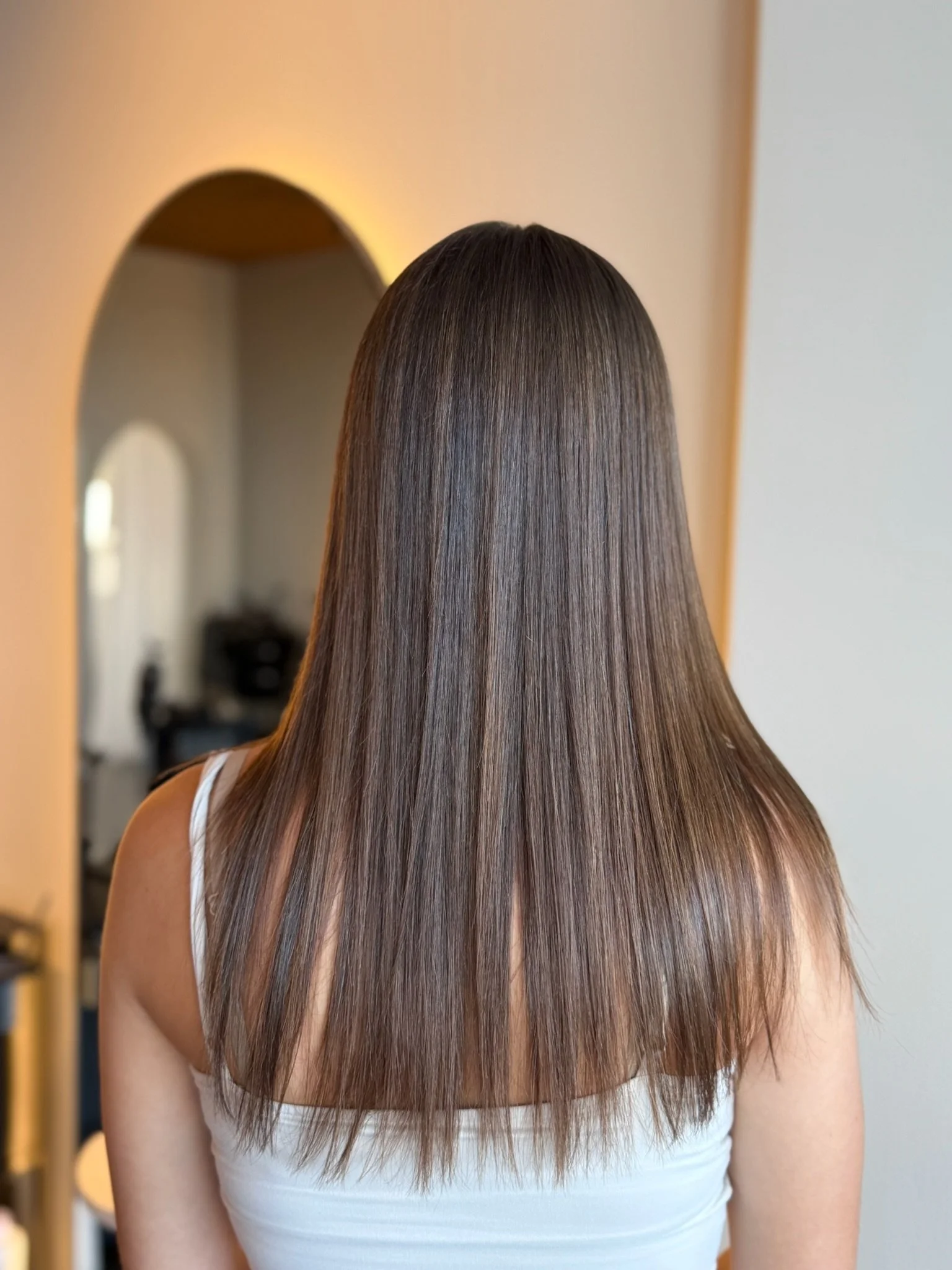 Smooth sleek hair result after Nanoplasty hair straightening treatment at Straight & Sleek salon.