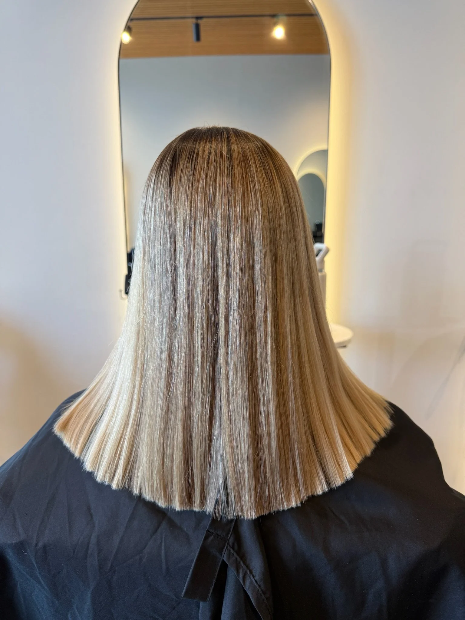 After Nanoplasty hair straightening showing smooth sleek blonde hair result at Straight & Sleek salon.