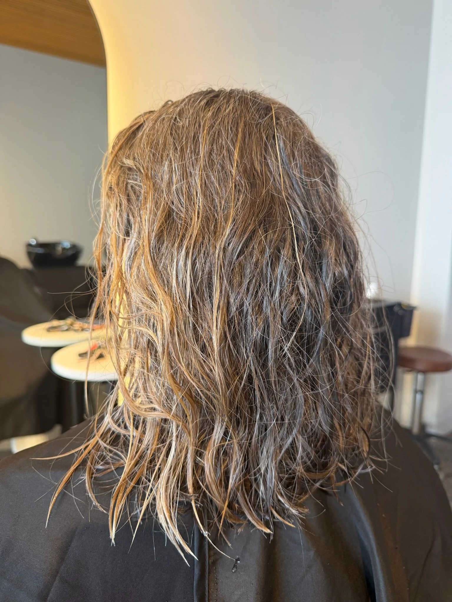 Before Nanoplasty hair straightening showing frizzy wavy blonde hair prior to treatment at Straight & Sleek salon.