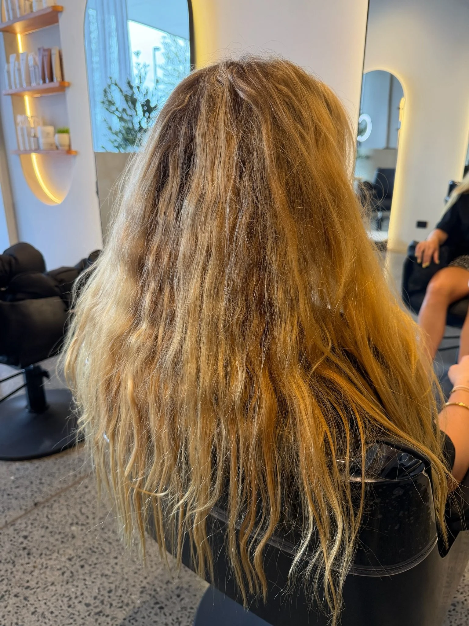 Before Nanoplasty hair straightening showing frizzy wavy blonde hair prior to treatment at Straight & Sleek salon.