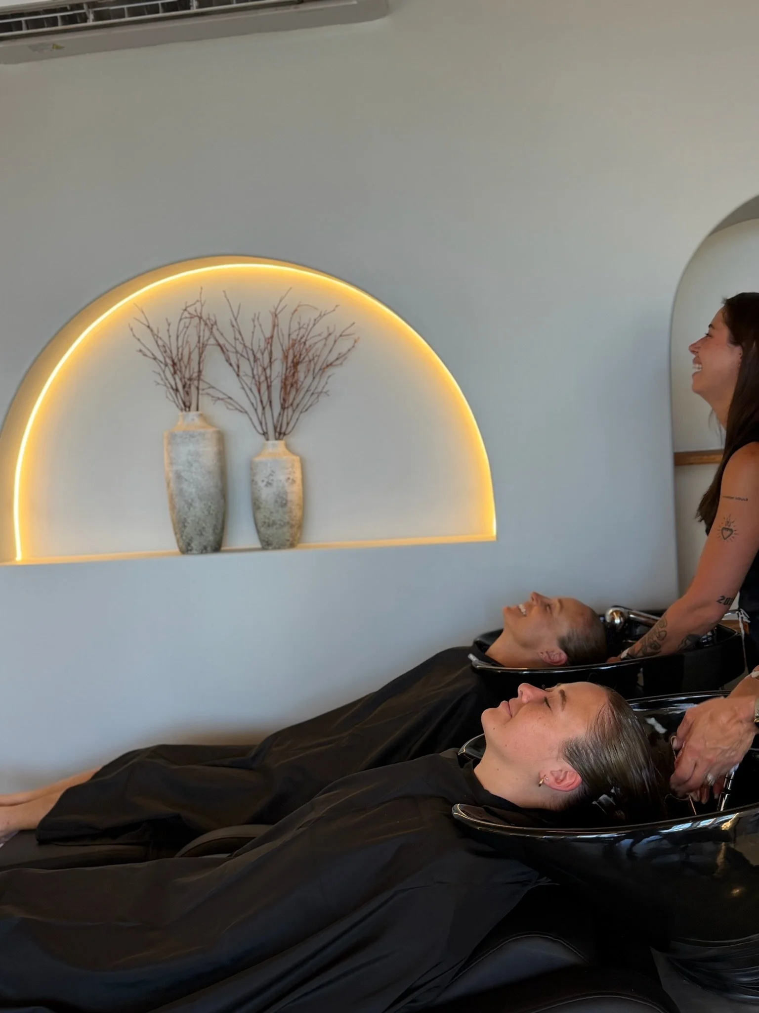 Clients having their hair washed during the Nanoplasty hair straightening preparation stage at Straight & Sleek salon.