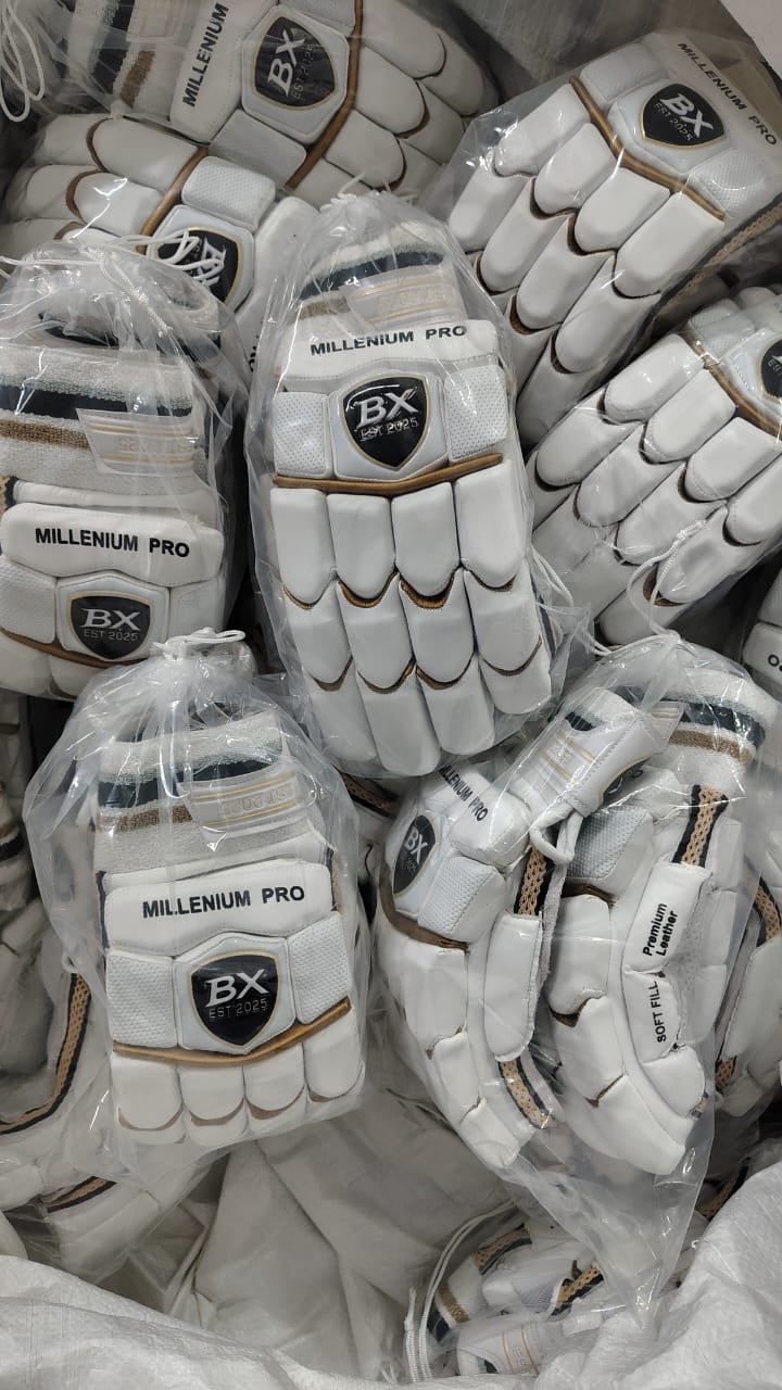 Several white cricket gloves labeled 'MILLENNIUM PRO' and 'BX EST 2025' packed in transparent plastic bags, stacked together.