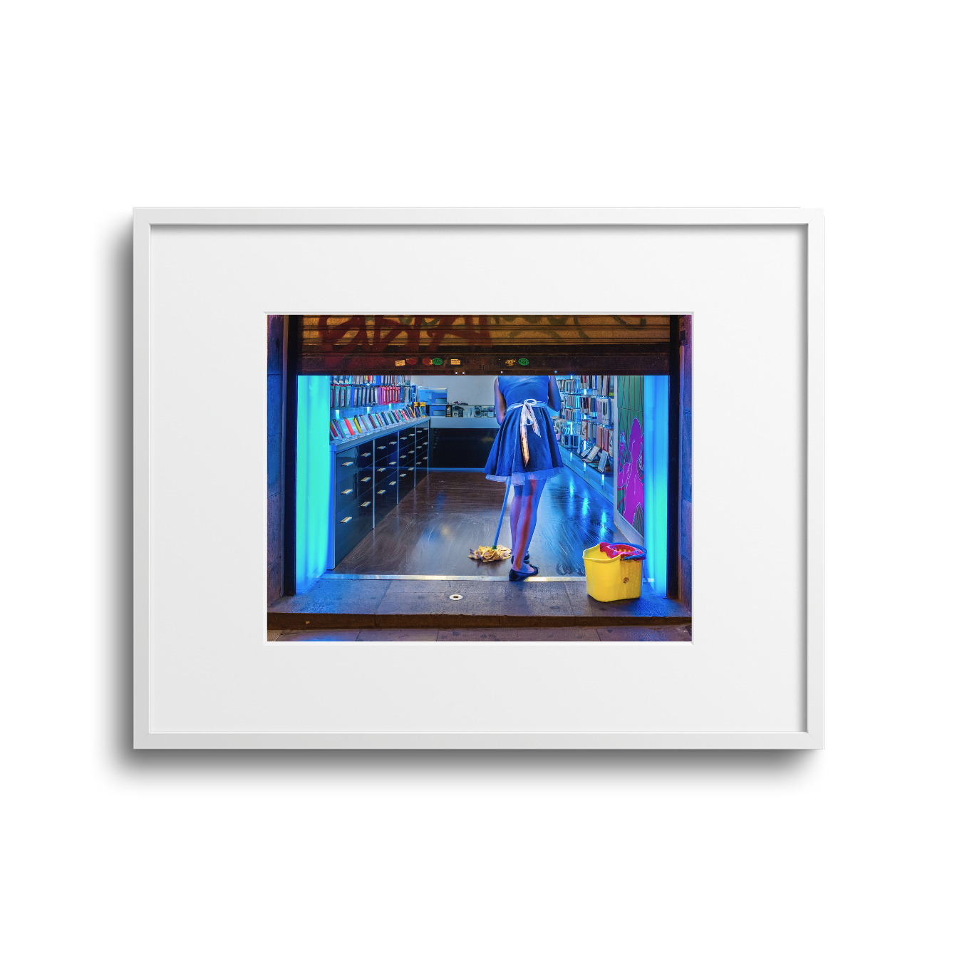 Person in a blue dress mopping the floor inside a bookstore with bright blue lighting.