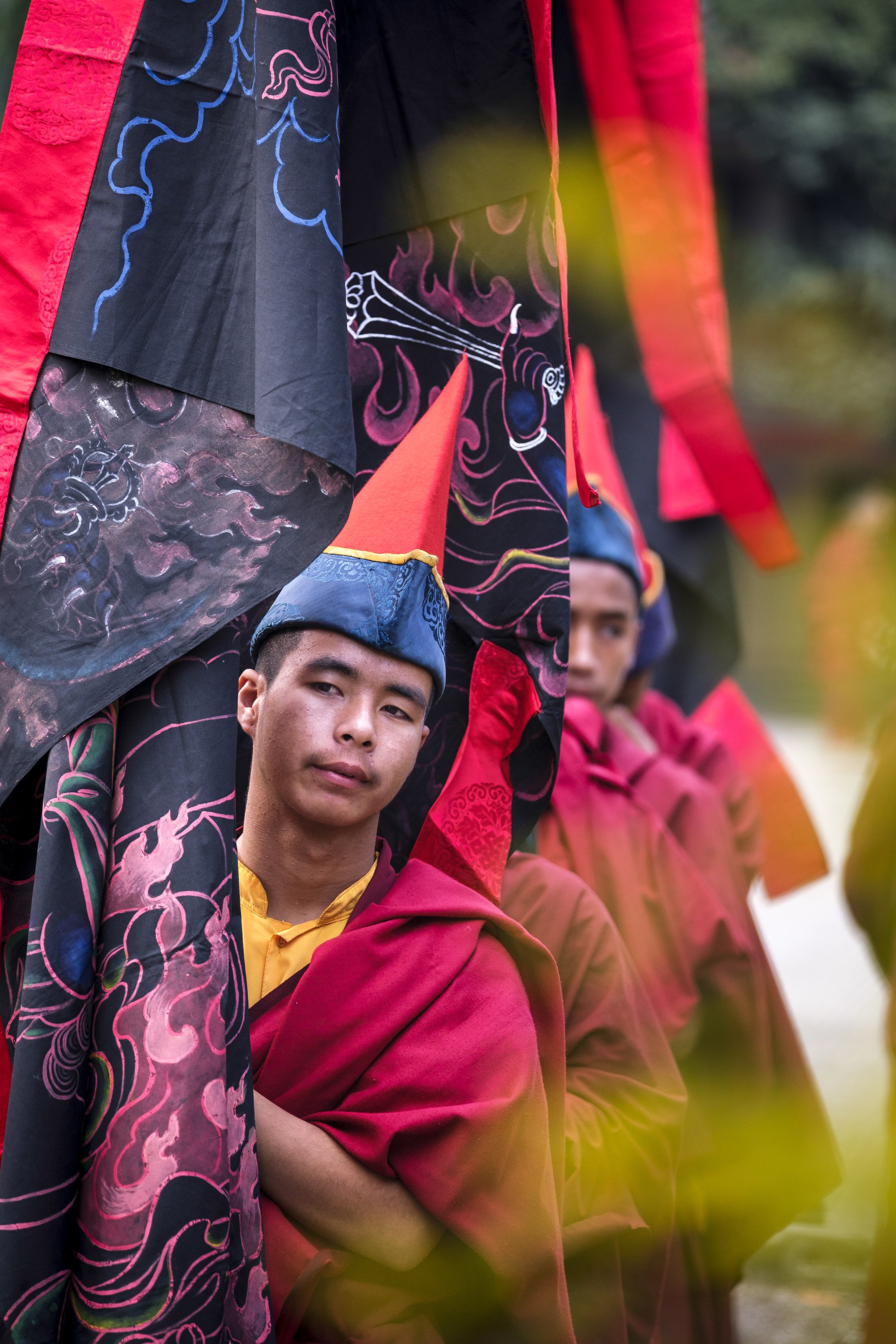 Young monk holding ceremonial banners during Gutor Chenmo ritual procession at Pal Dilyag Monastery in Kathmandu.