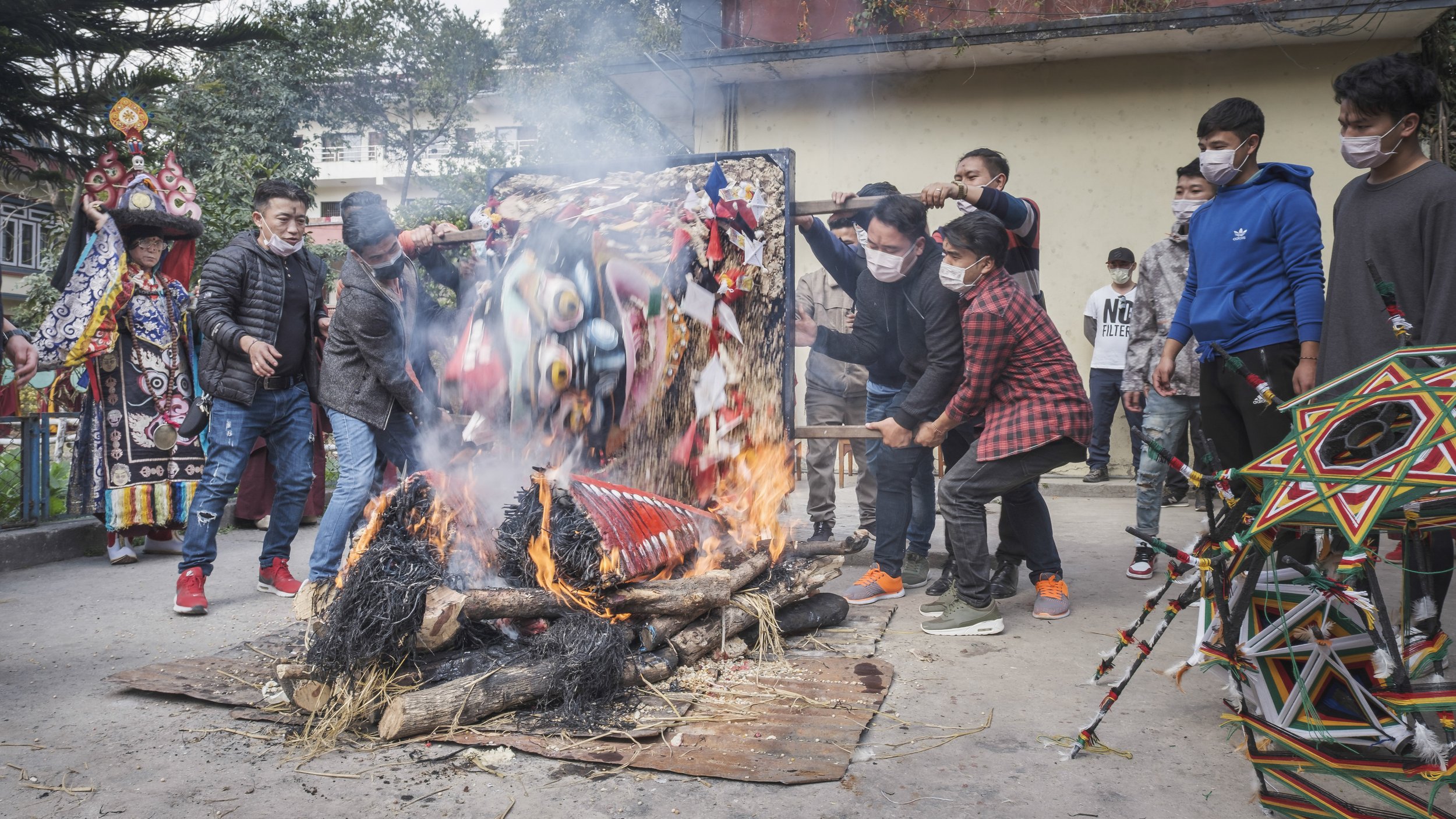 Community members and monks burning the Mahakala torma during the Gutor Chenmo ritual symbolizing purification and impermanence in Kathmandu.