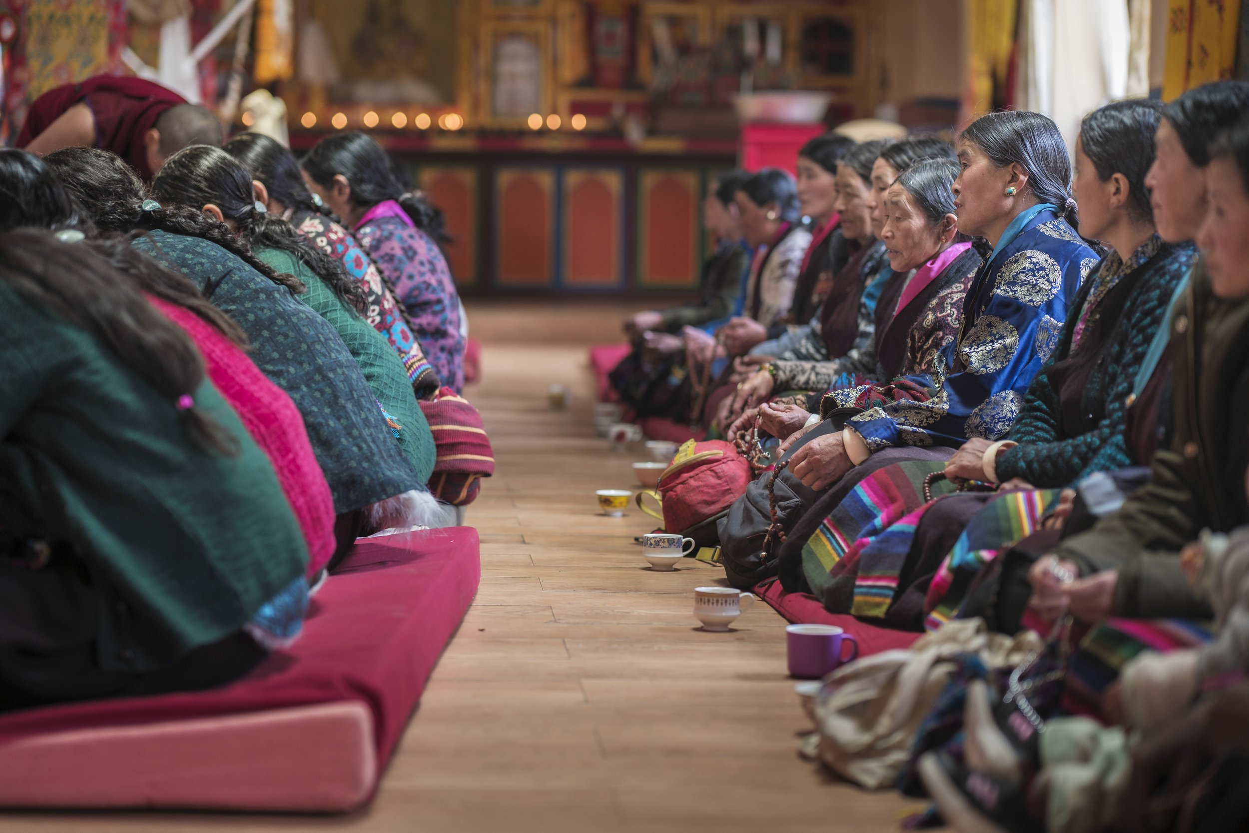 Women gathered in a monastery prayer hall during a communal ritual in Tsum Valley, Nepal.