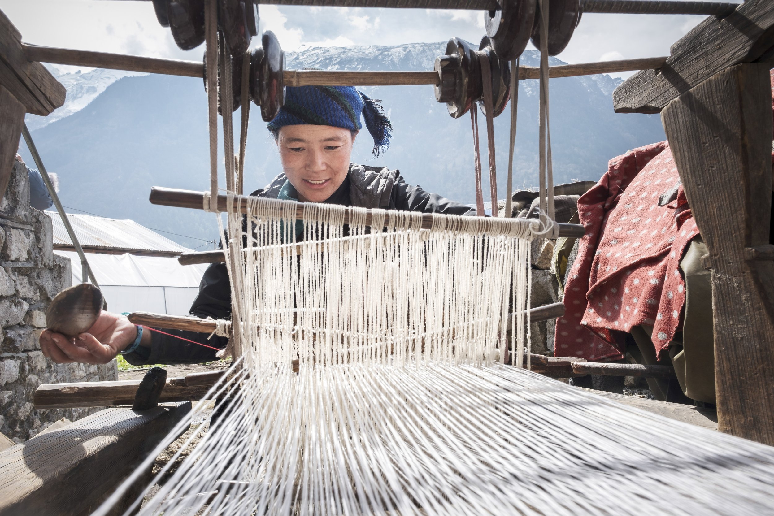 In Chekkampar, Sangmo turns to her loom between welcoming trekkers and tending the guesthouse. Weaving remains central to life in Tsum Valley, shaping clothing, household needs, and small income, while carrying forward patterns learned from mothers a
