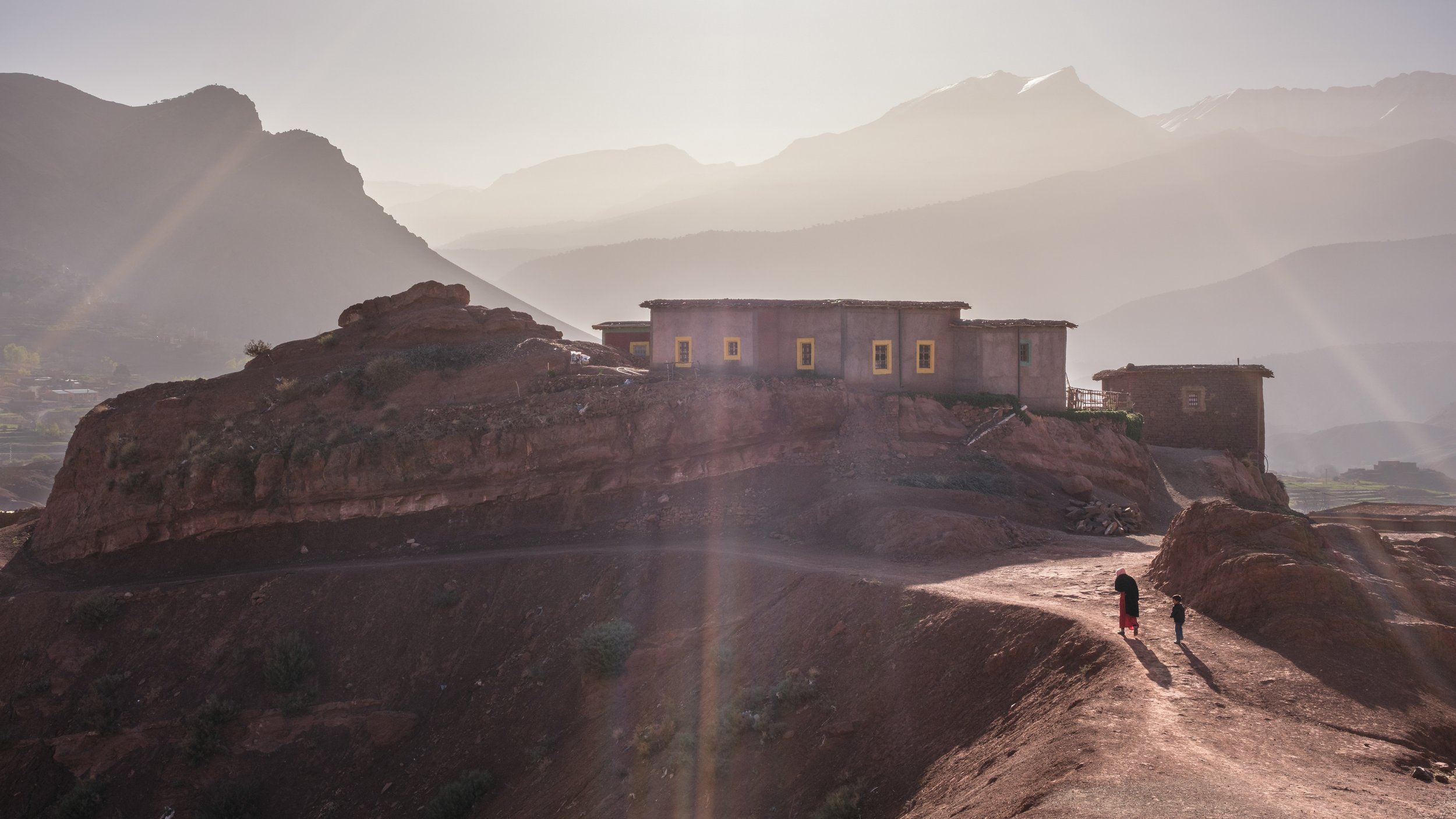 Traditional house on a rocky hillside at sunrise in the High Atlas Mountains near Aït Bouguemez Valley.