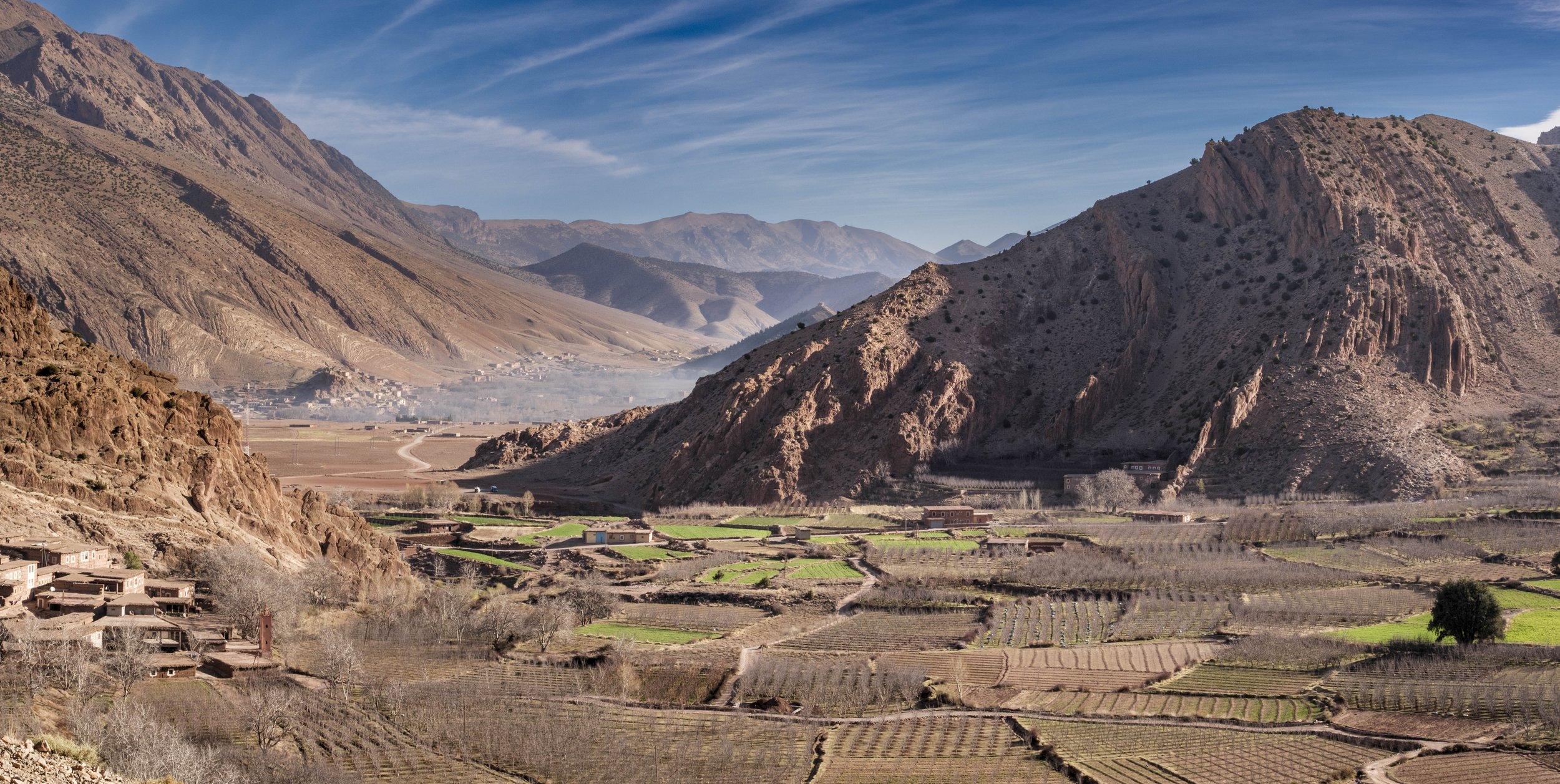 Terraced agricultural fields beneath steep mountain slopes in the Aït Bouguemez Valley of Morocco.