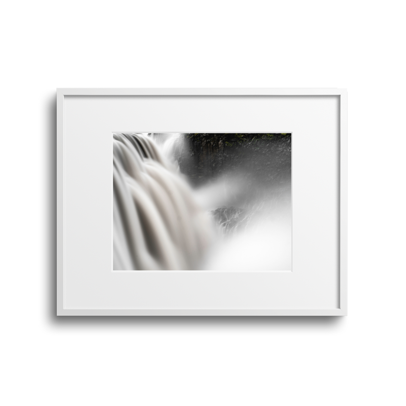 Framed photograph of a waterfall with flowing water and mist, on a white background.