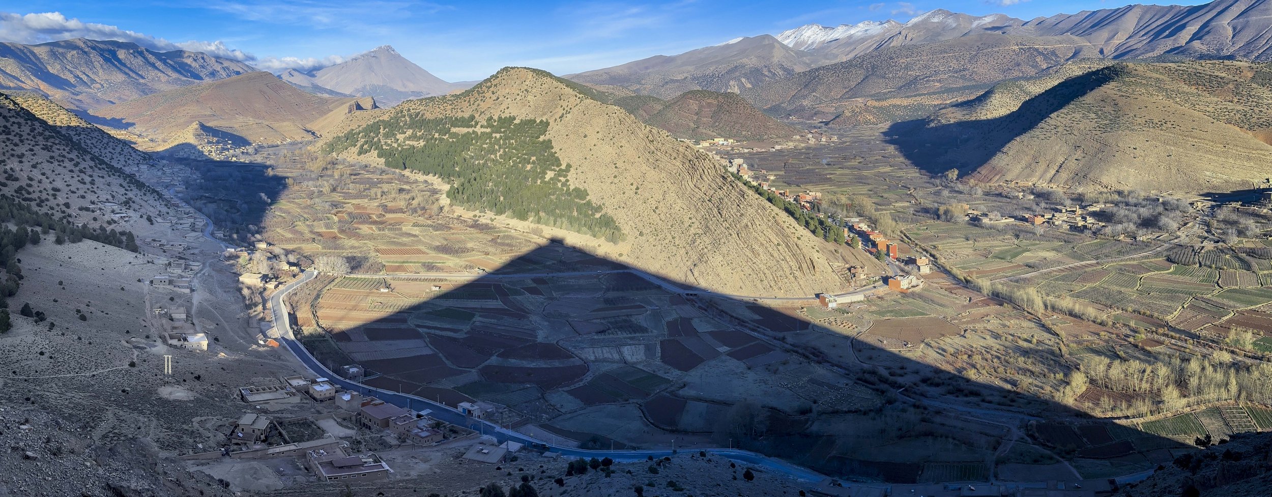 Panoramic view of terraced fields and villages across the Aït Bouguemez Valley in the High Atlas Mountains.