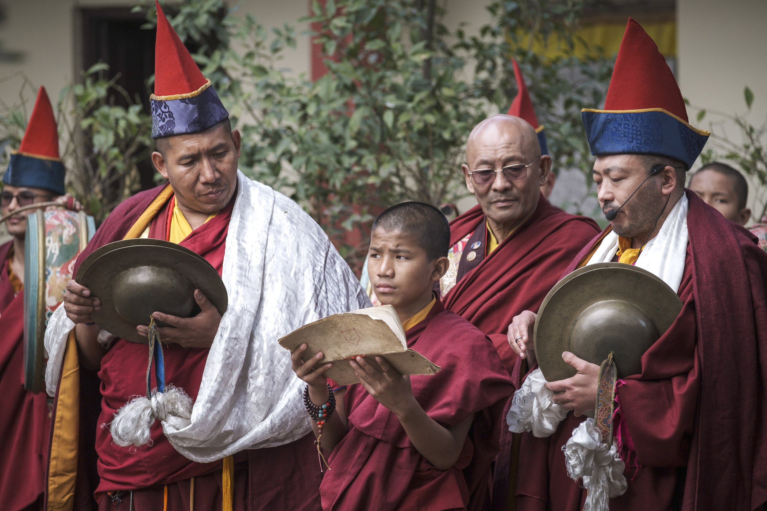 Tibetan Buddhist monks and a young novice reading from a text during the Gutor Chenmo ritual at Pal Dilyag Monastery in Boudhanath, Kathmandu.
