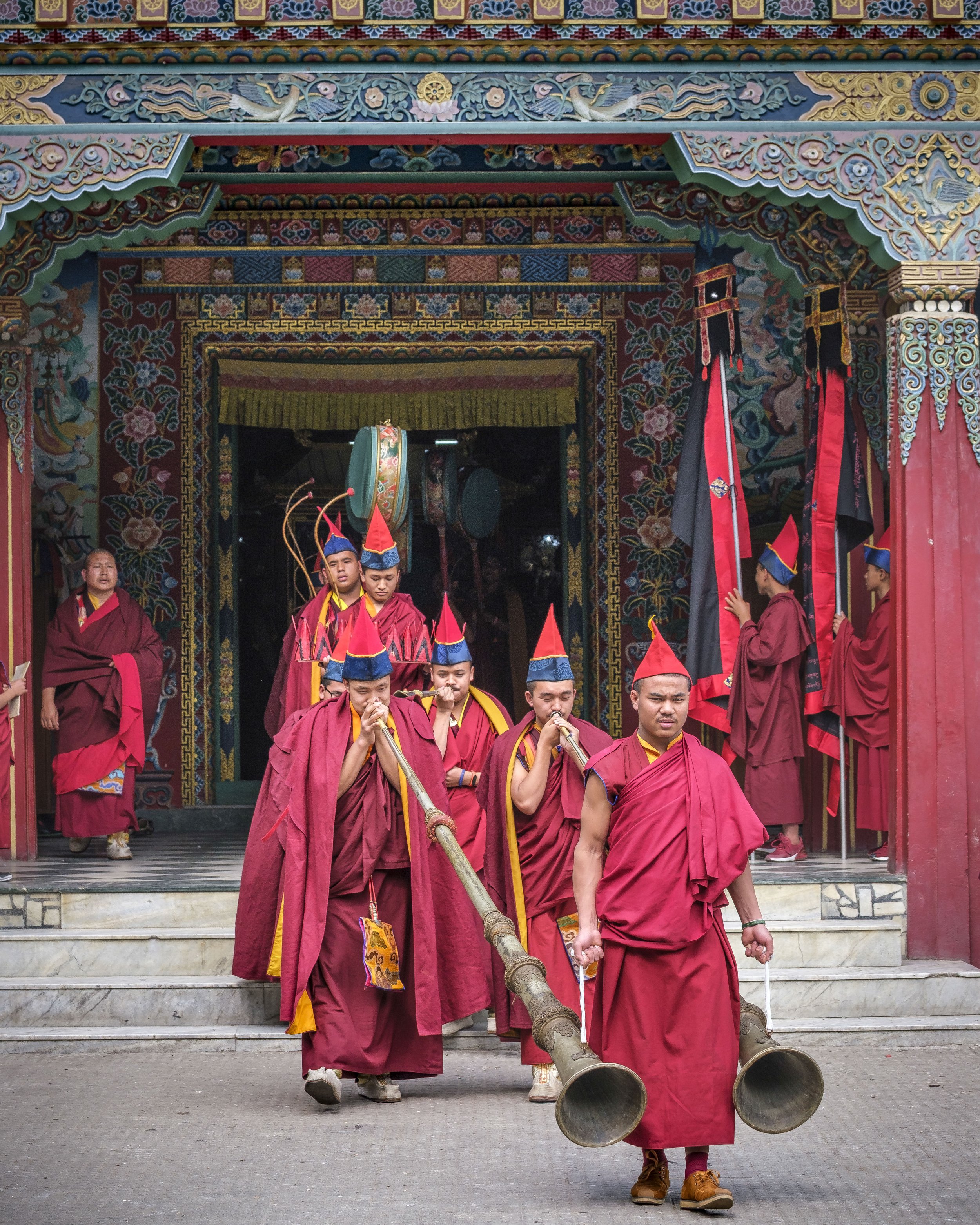 Monks playing dung chen horns exiting the monastery during Gutor Chenmo ritual procession in Boudhanath, Kathmandu.