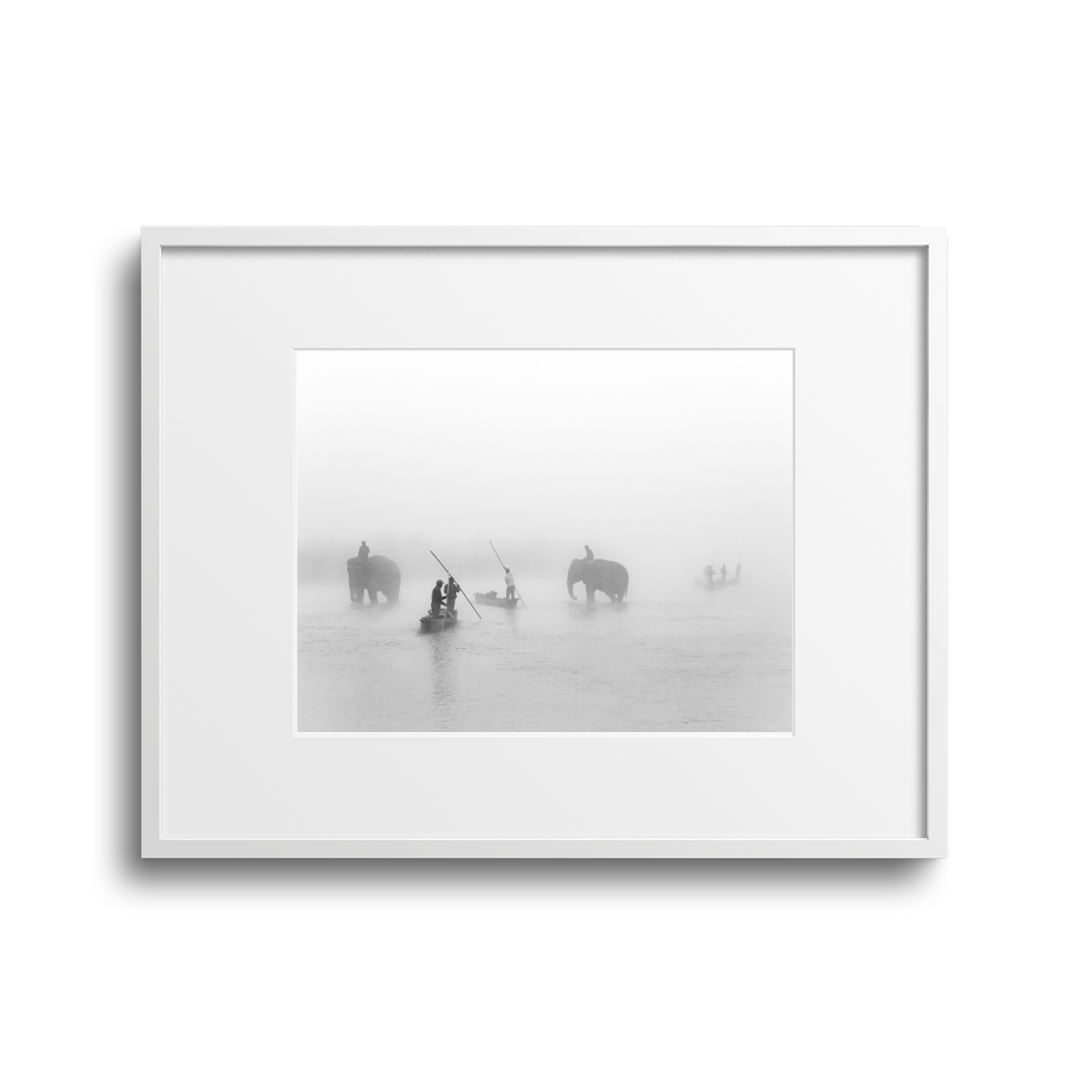 Black and white photograph of three elephants in water, accompanied by people on small boats, with foggy or misty background.