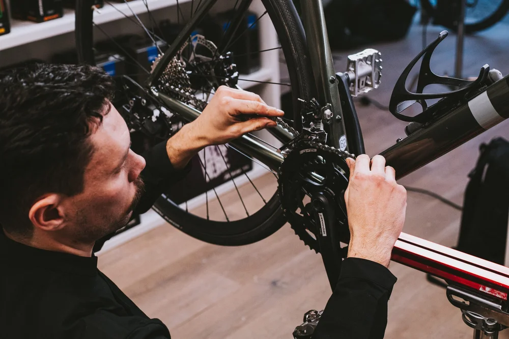Monteur werkt aan de aandrijving van een racefiets