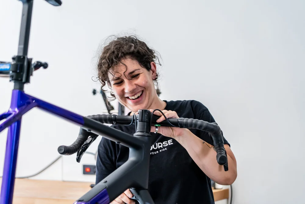 Monteur van Concourse monteert lachend een stuur op een racefiets
