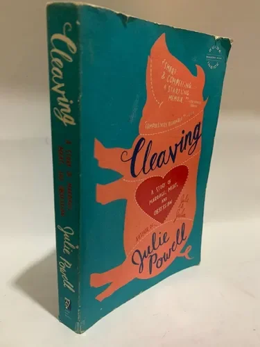 A teal bookstore paperback book titled 'Unleashing' by Julie Powell, with an orange dog silhouette on the cover.