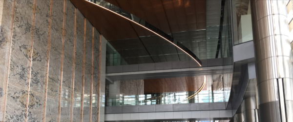 Interior view of a modern building with glass, wood, and metal architectural features.