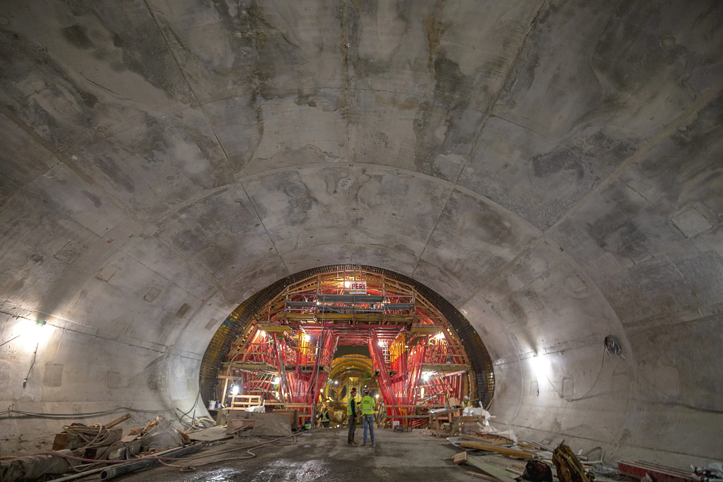 Underground tunnel under construction with scaffolding and workers