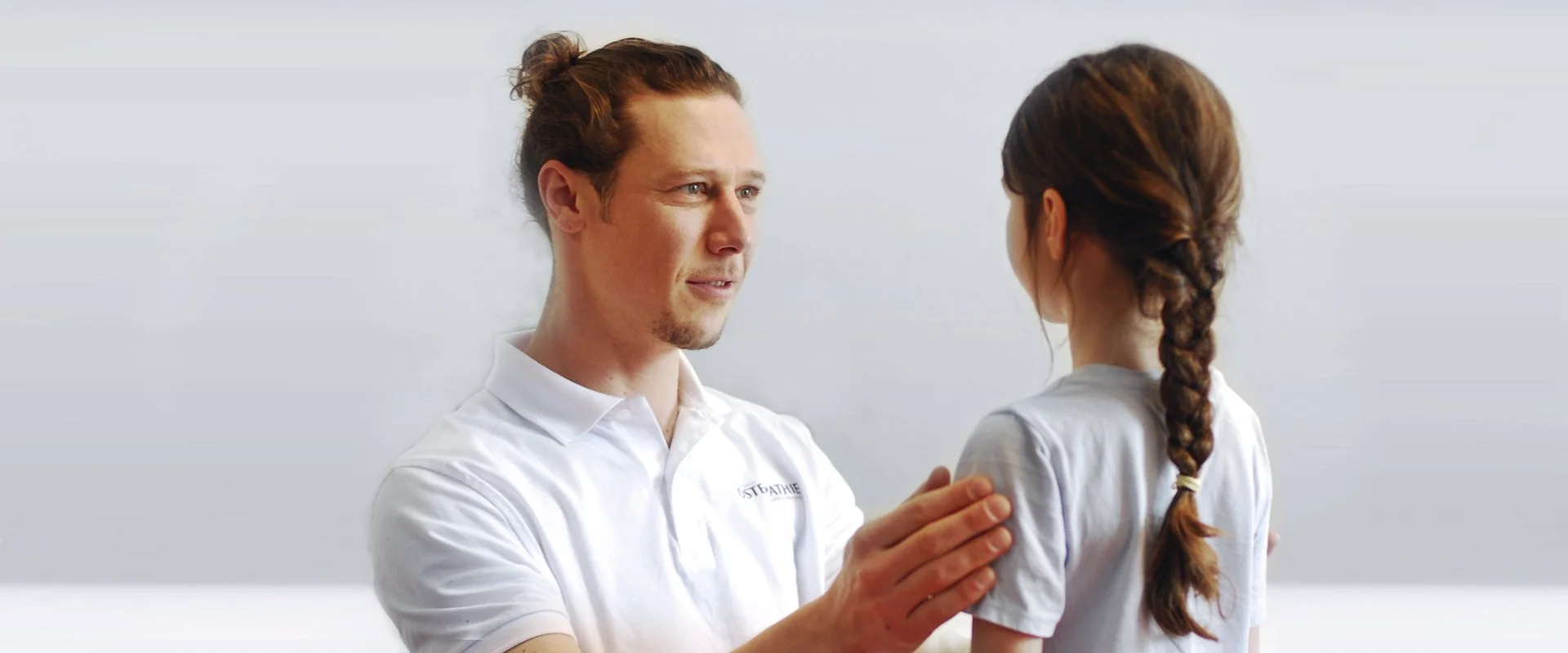 Ein männlicher Arzt spricht mit einem jungen Mädchen in einer Arztpraxis.