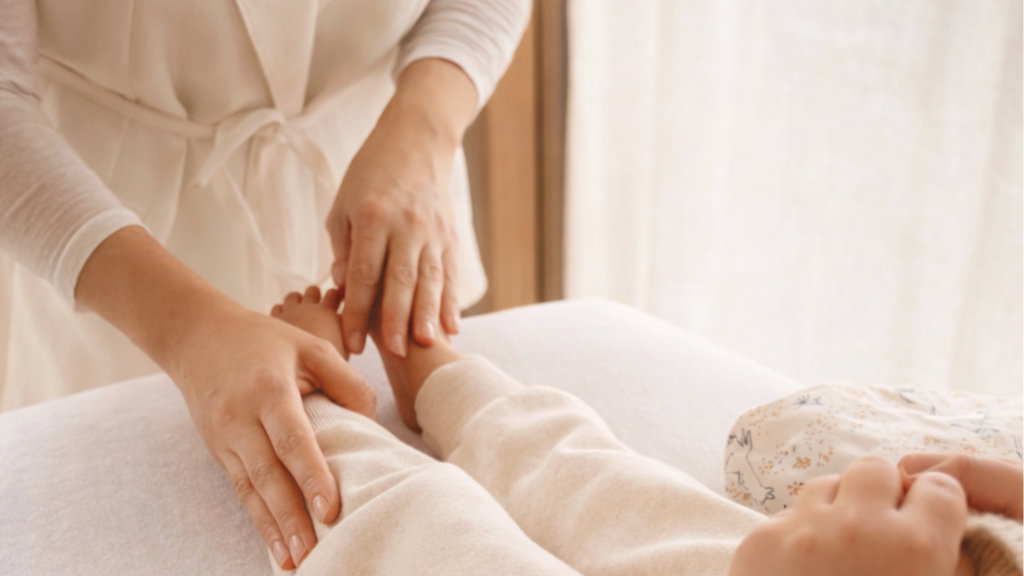 Une personne recevant un massage des bras par un thérapeute dans un environnement calme et lumineux.