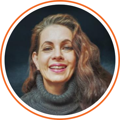 A woman with long brown hair smiling, wearing a dark gray turtleneck sweater, against a dark background.