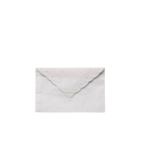 A white piece of cloth with embroidered decorative circles, folded in an envelope style.
