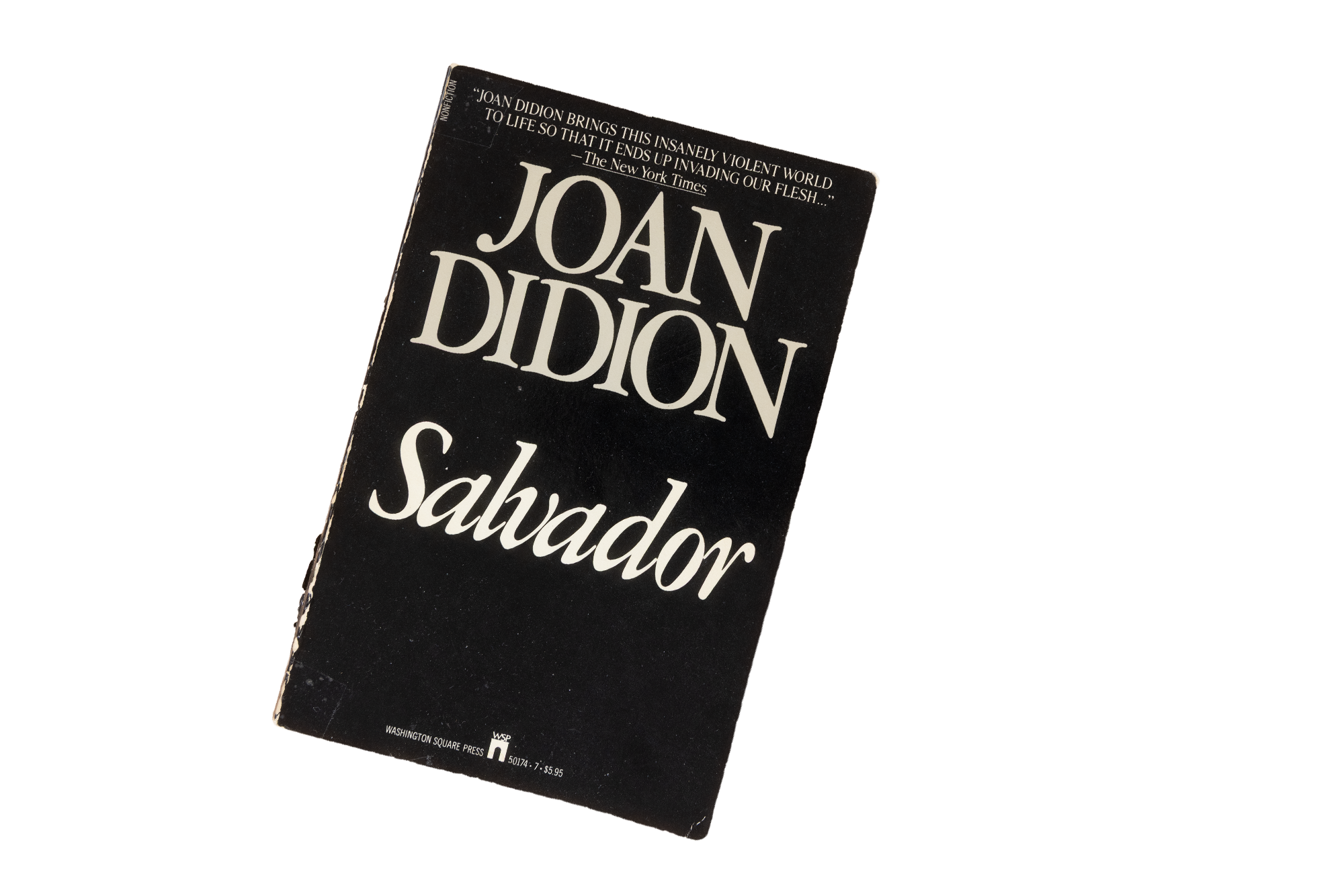 Close-up of the book "SALVADOR" by Joan Didion, with a black cover and white text.