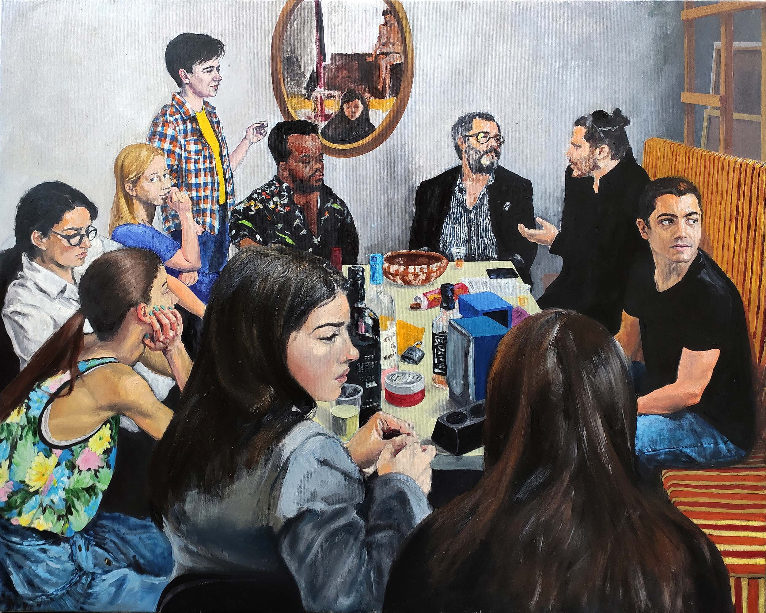 A group of people sitting around a long dining table engaged in conversation, with some drinking, in a cozy restaurant setting.