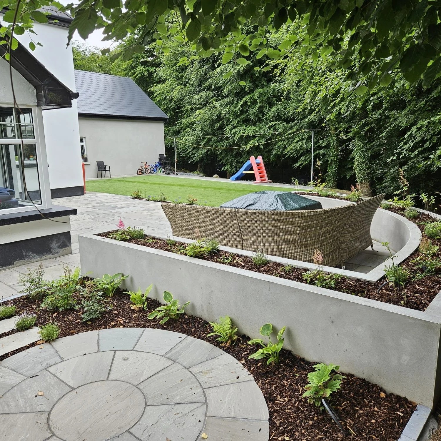 Kandla Grey Sandstone circle surrounded in planters and natural stone patio