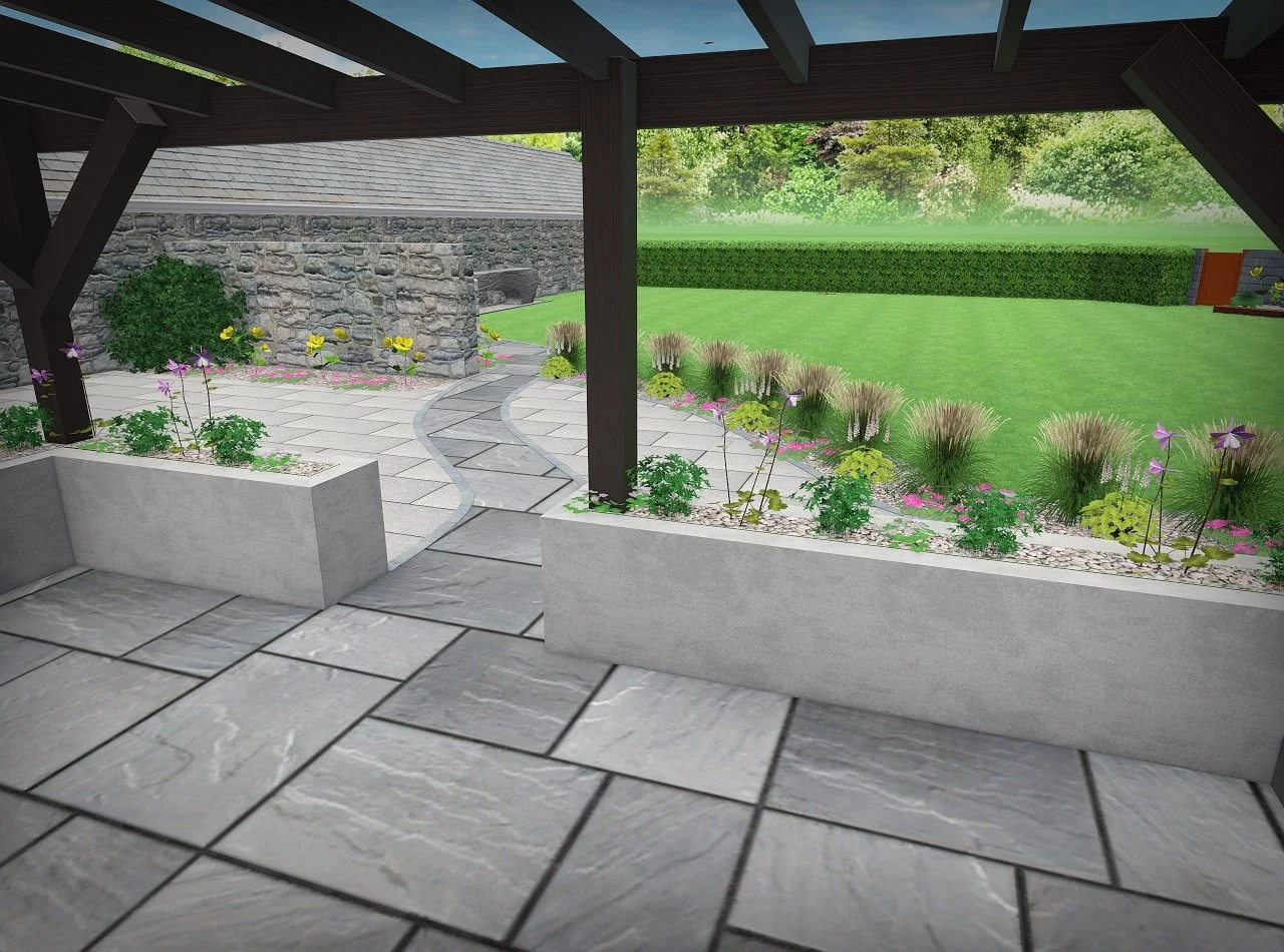 View from a covered patio overlooking a landscaped backyard with a stone pathway, flower bed, green lawn, and trees in the background.