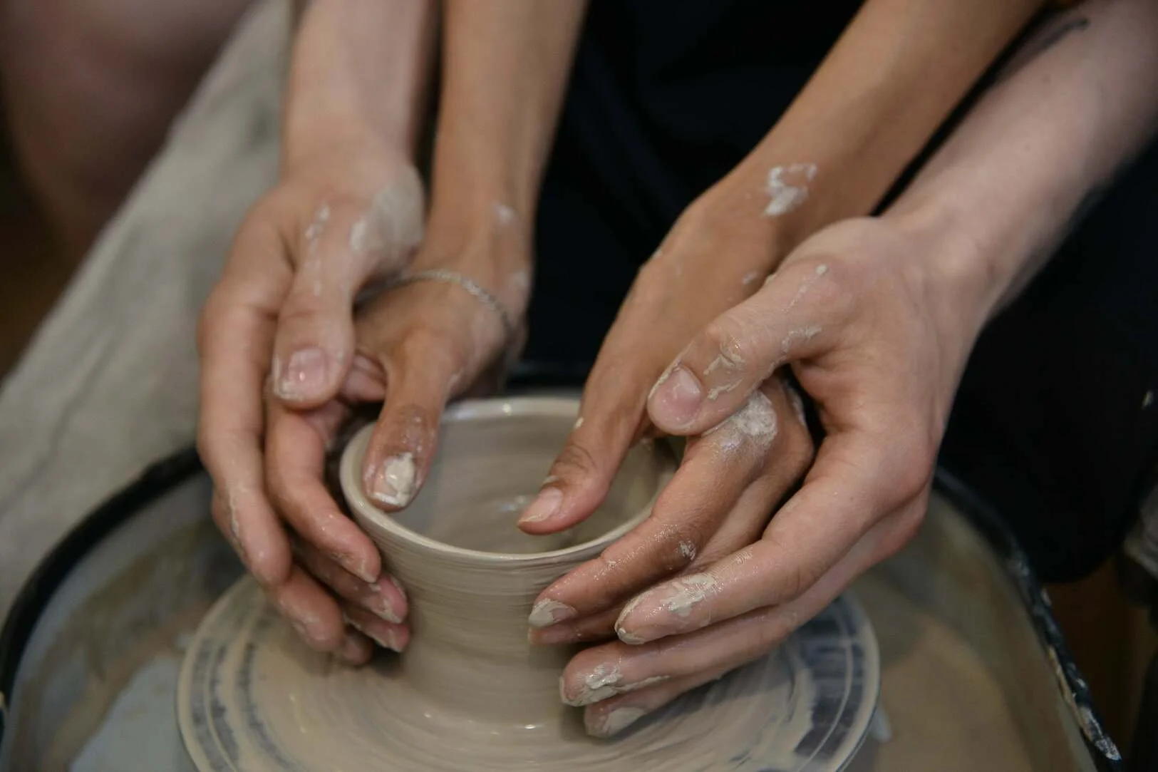  a man and a woman behind a potter's wheel  