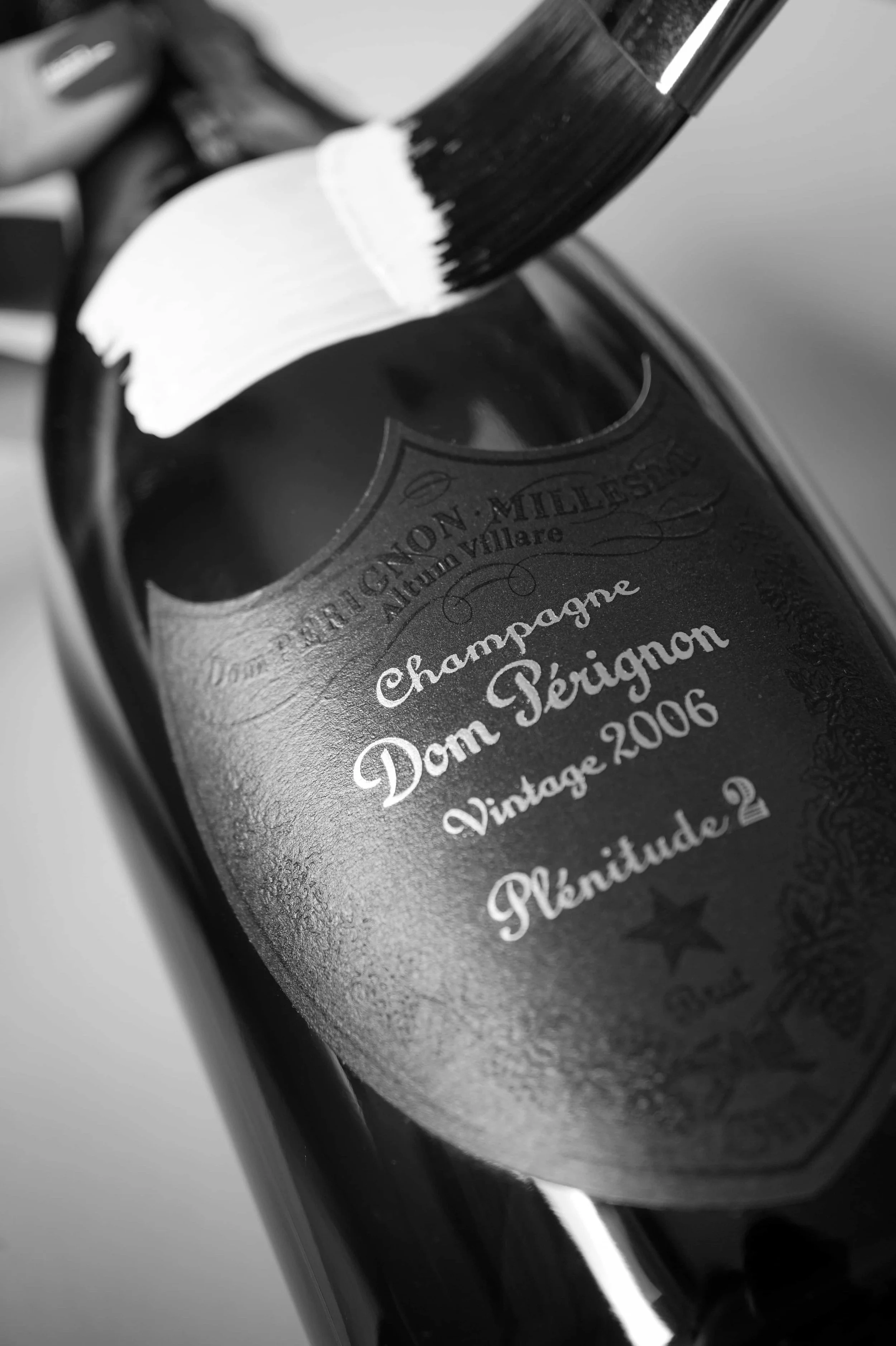 Black and white close-up of a hand-painted Dom Pérignon Plénitude 2 champagne bottle