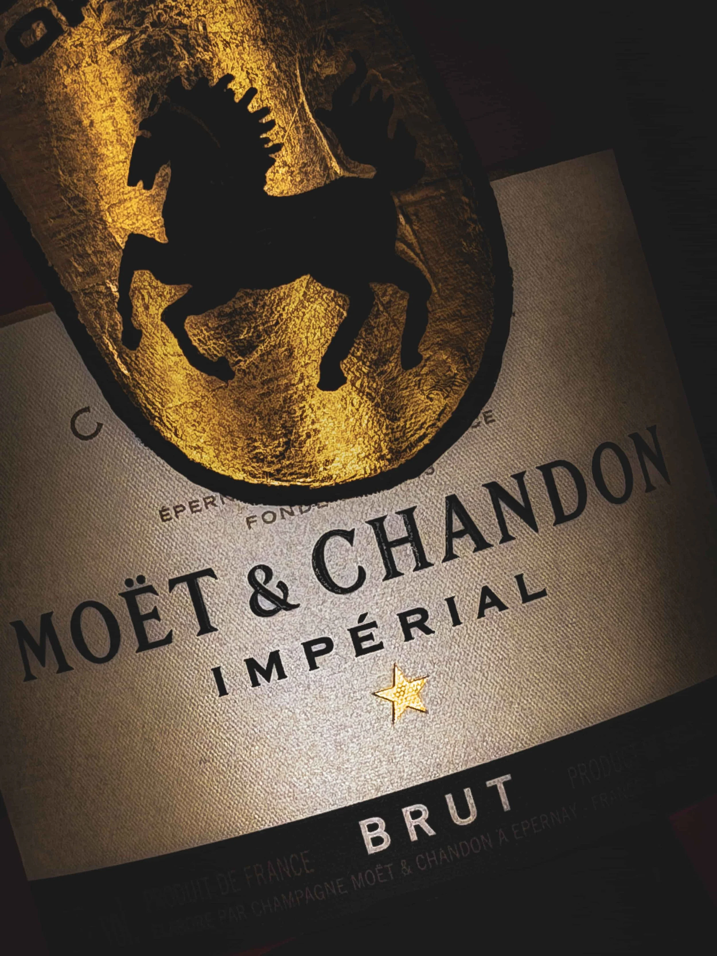 Close-up of gold leaf detail on a hand-painted Moët & Chandon Impérial Brut champagne bottle