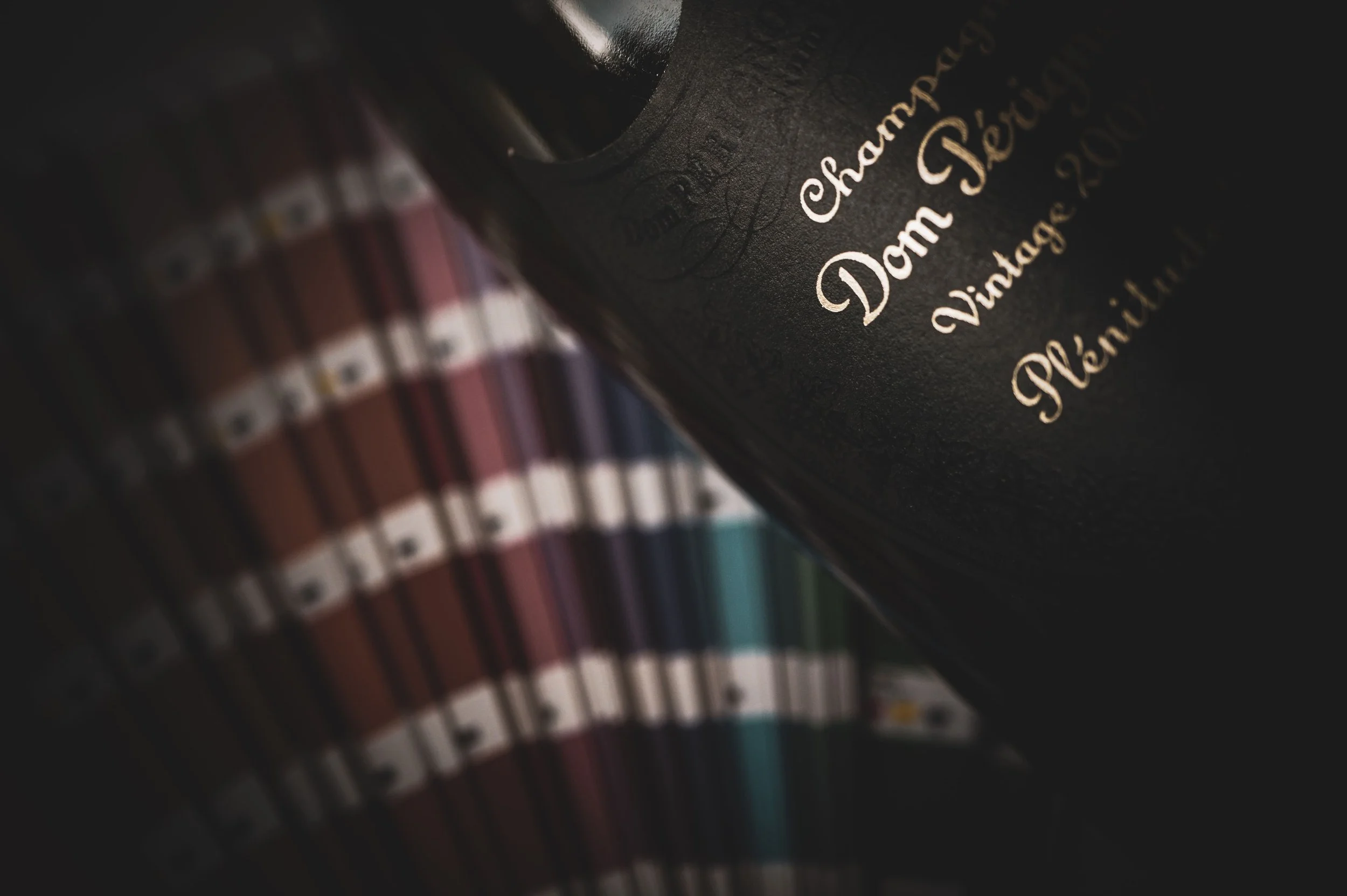 Close-up of a hand-painted Dom Pérignon bottle with colorful paint swatches and gold logo