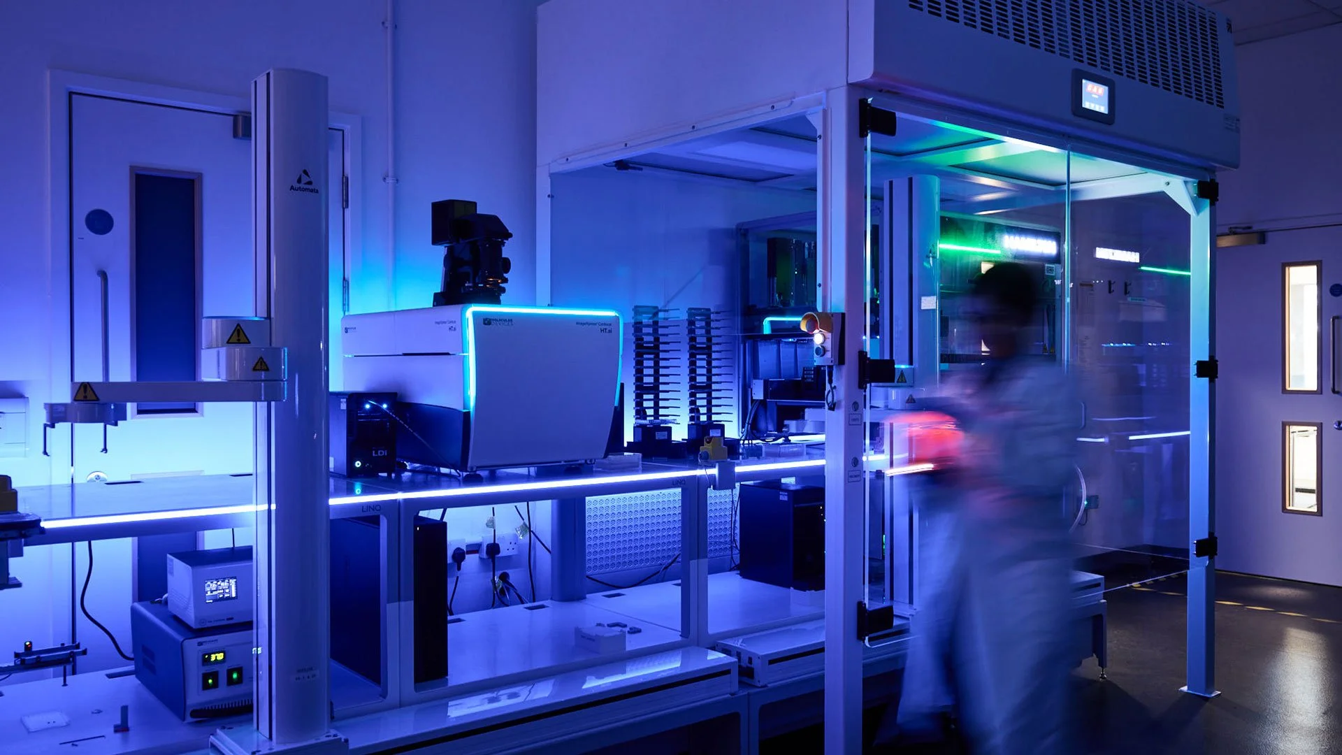 A person working in a high-tech laboratory with advanced equipment and blue LED lighting. Based at Science Creates Old Market, a 33,000 sq ft Deep Tech incubator in Bristol, UK