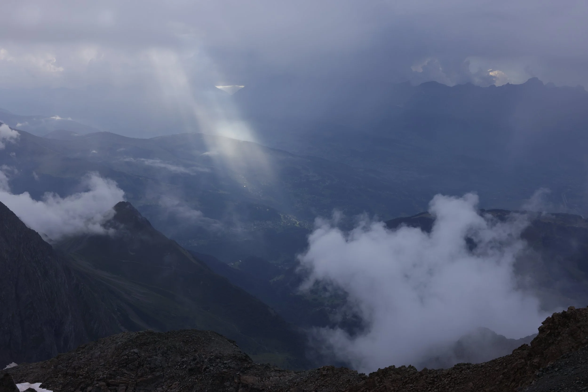 Mountain landscape with clouds and sun rays breaking through the sky