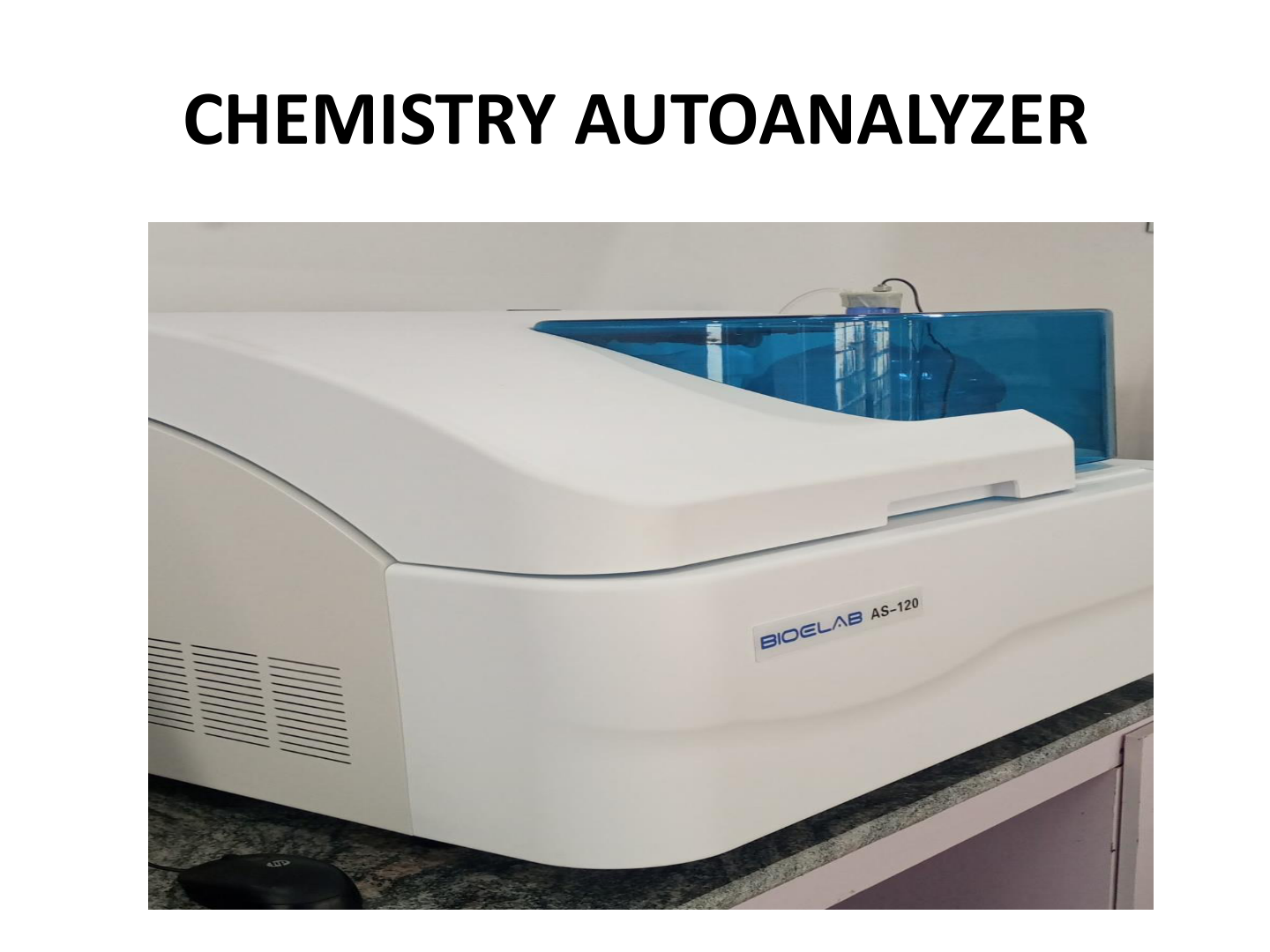 A white chemistry autoanalyzer machine with a blue transparent cover, labeled 'BIOELAB AS-120', placed on a countertop in a laboratory setting.