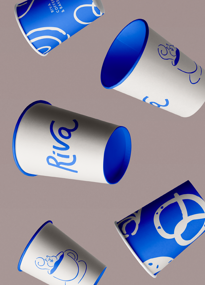 Paper cups with blue and white illustration for a modern coffee and bakery shop.