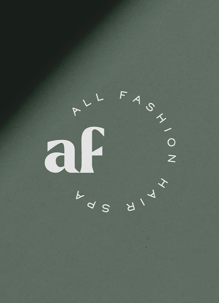 Close up of a circular logo with a monogram for a modern hair spa, green background.