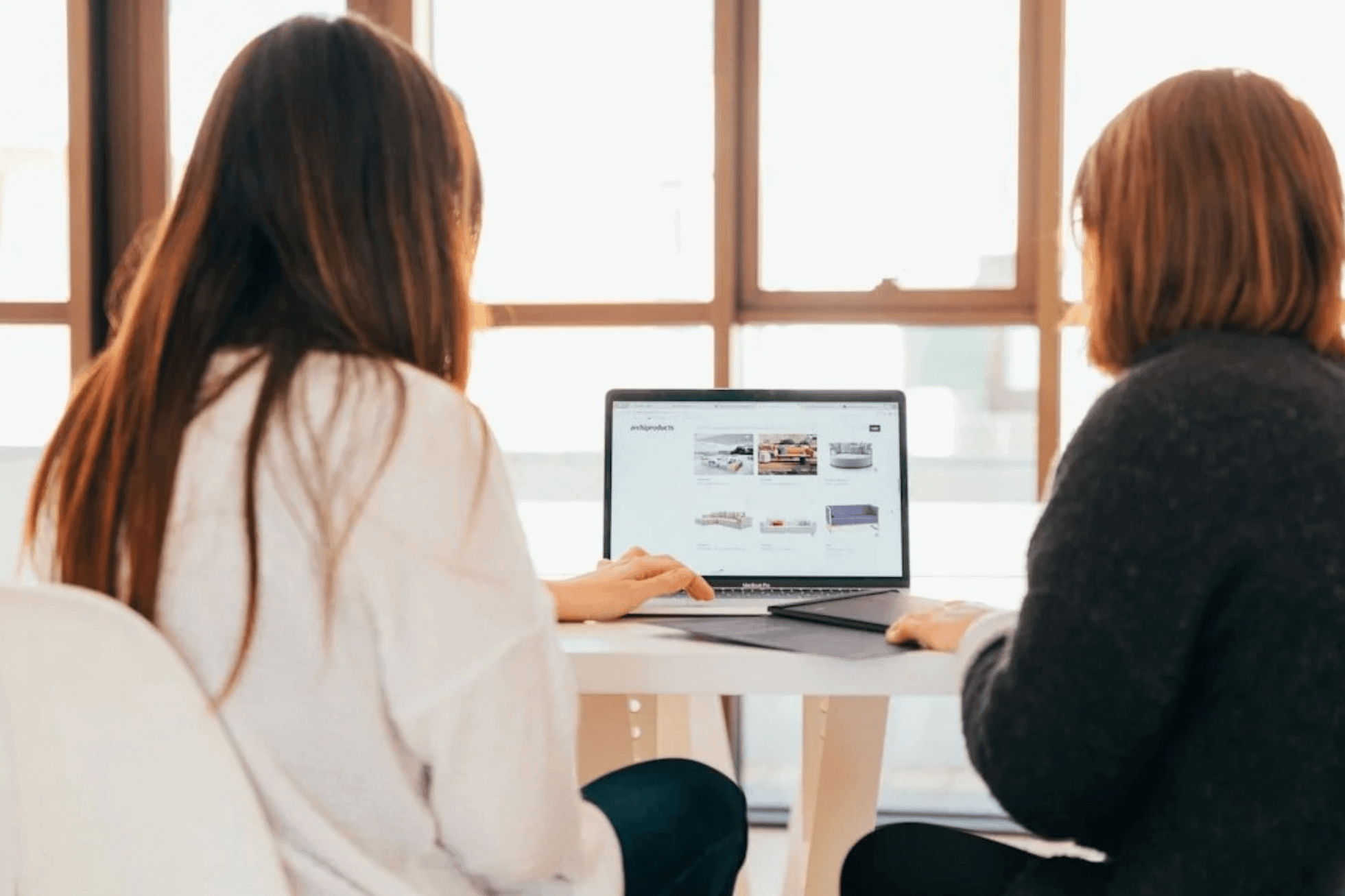 Two business owners reviewing a website design build on a laptop together