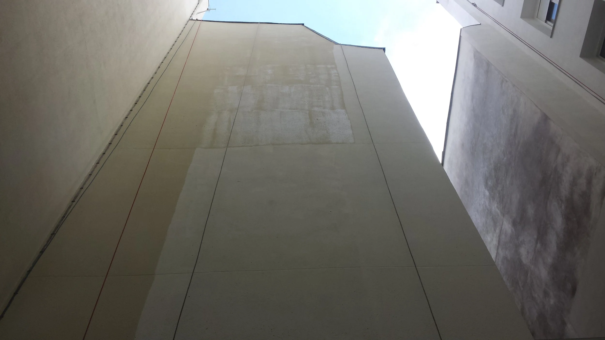 mise en peinture d'une façade à l'aide de corde