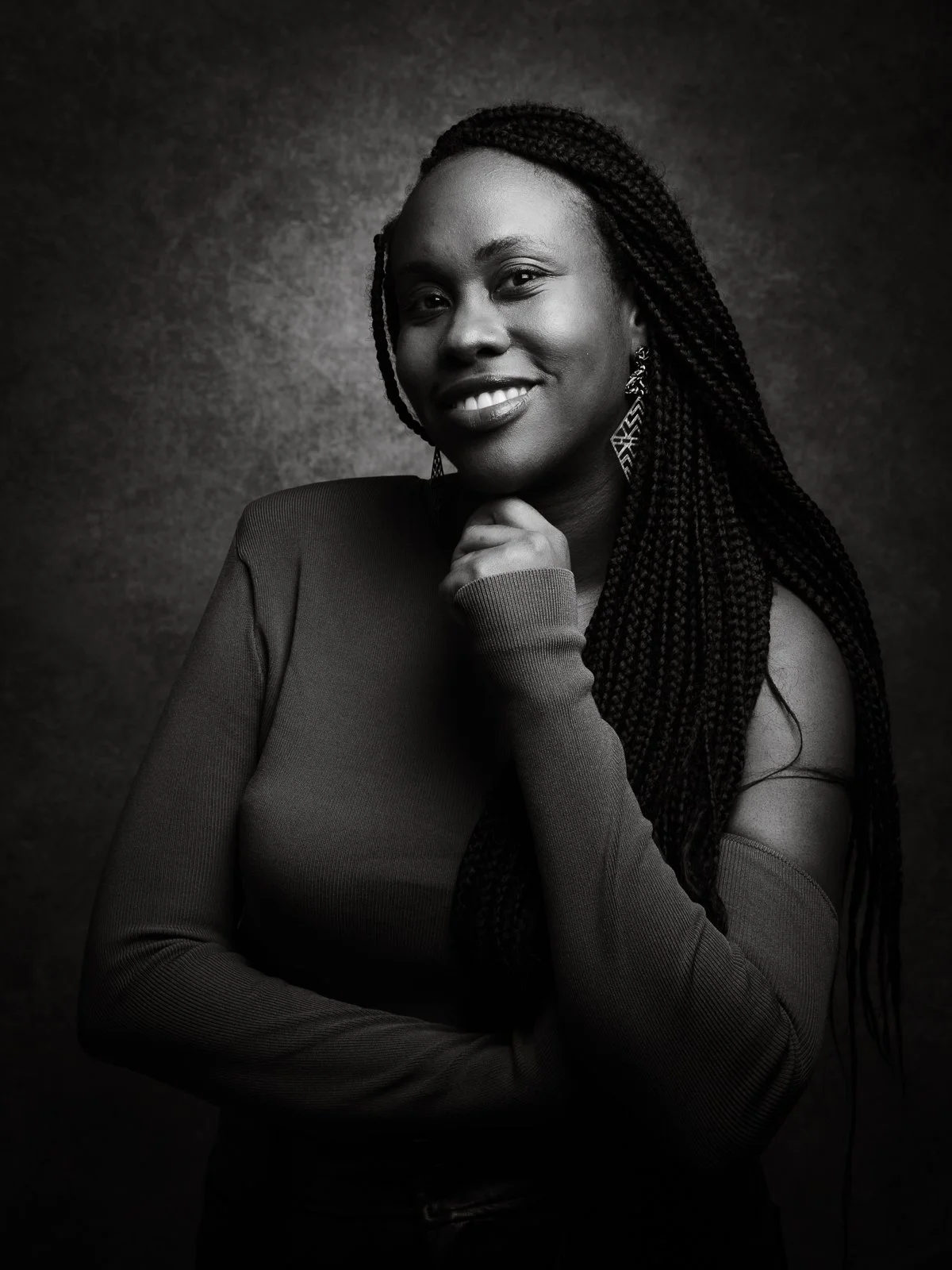 Portrait féminin en noir et blanc avec éclairage contrasté en studio.