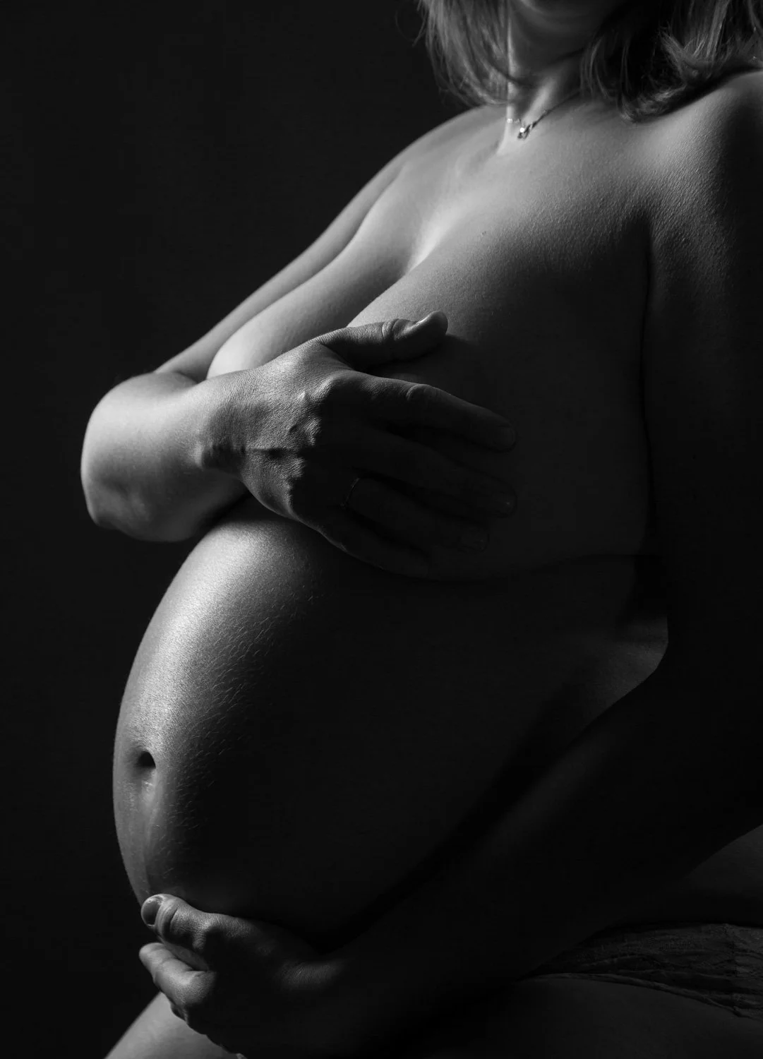 Photographie de grossesse en clair-obscur en studio
