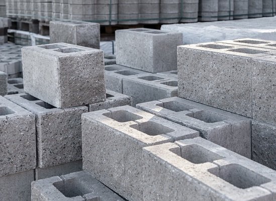 Stacked gray concrete cinder blocks at a construction site.