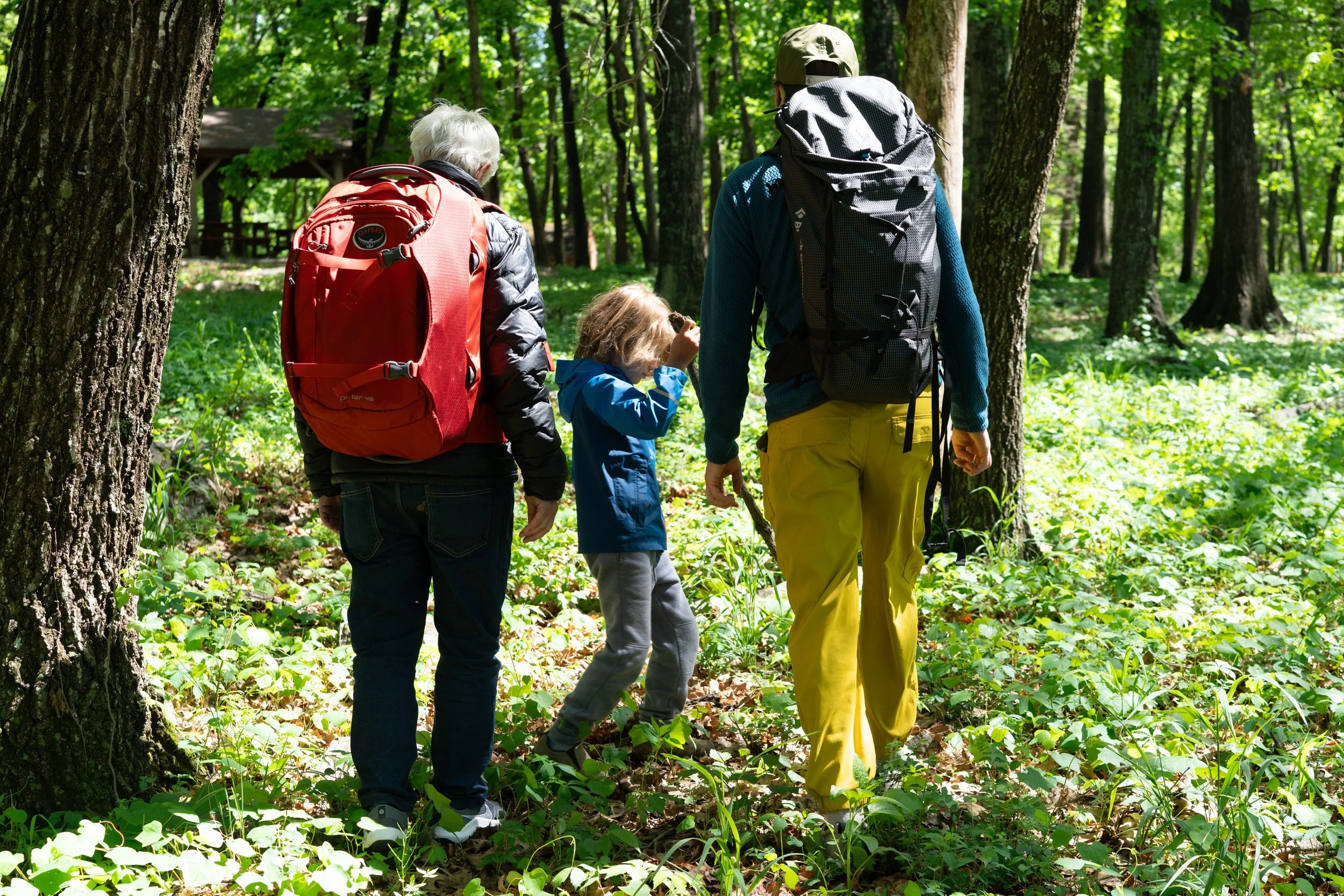 Older man wearing a used Osprey backpack, boy wearing a used Patagonia jacket, man wearing a used Black Diamond backpack